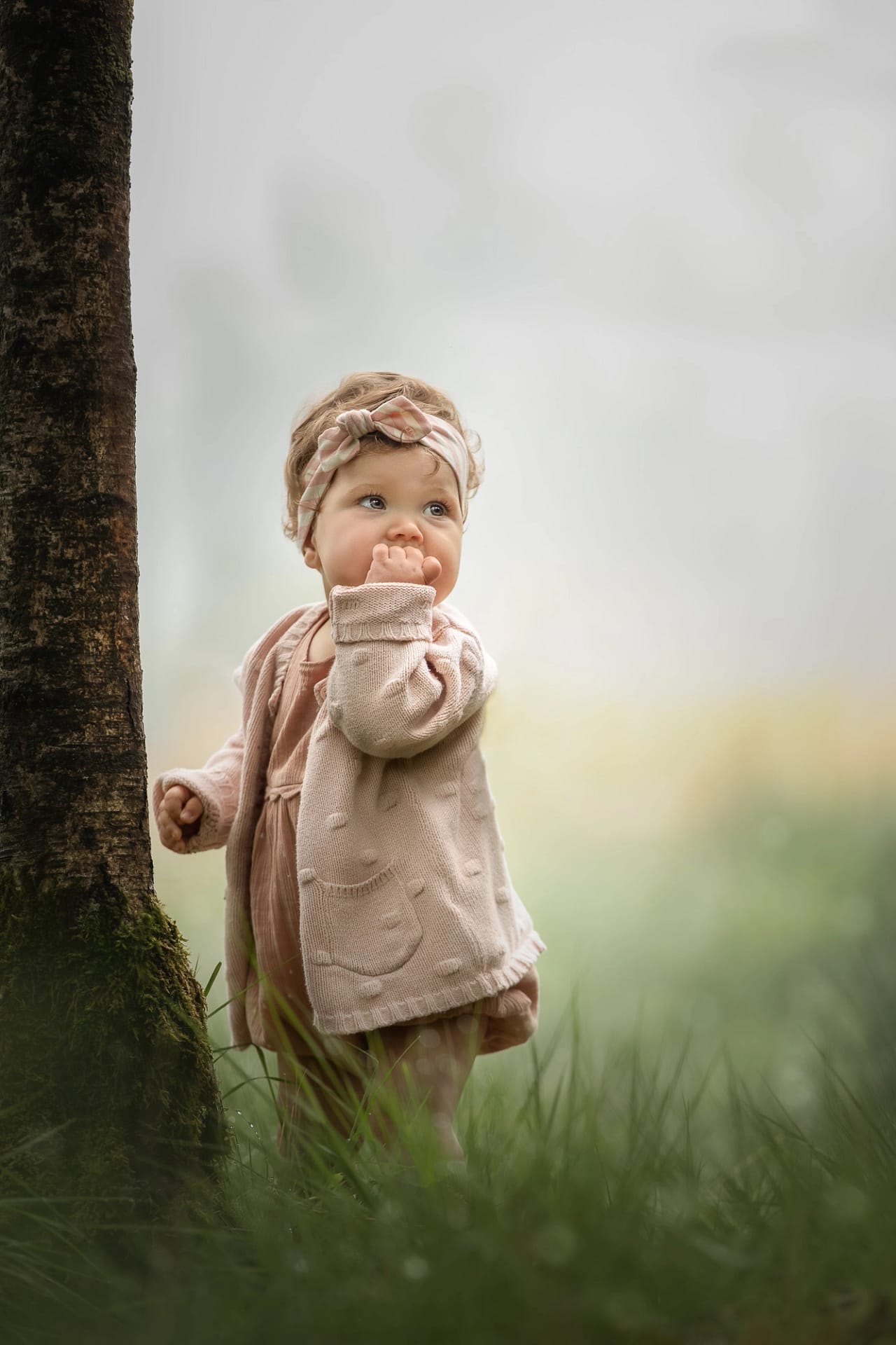 Child in a sweater playing in a scenic outdoor setting – timeless child portraiture